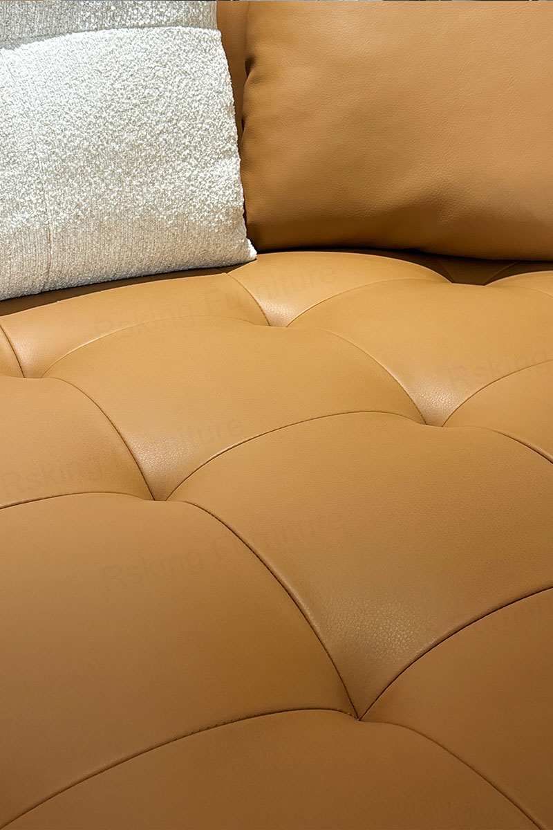 Close-up of the Rsking RSK2518 caramel leather seat with recessed tufting and a subtle surface sheen