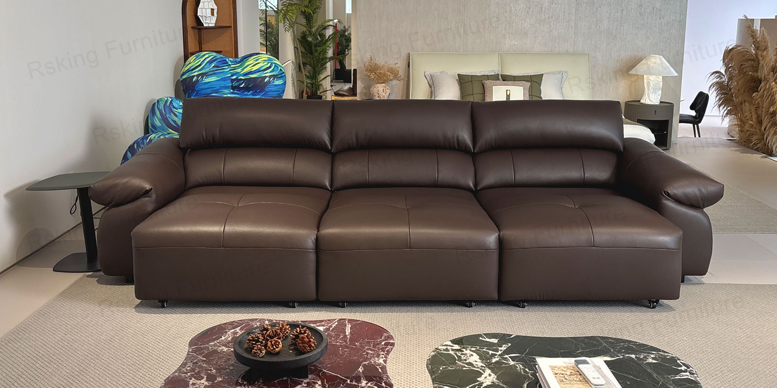 Dark brown three-seater sofa with the seating area extended forward beside stone coffee tables