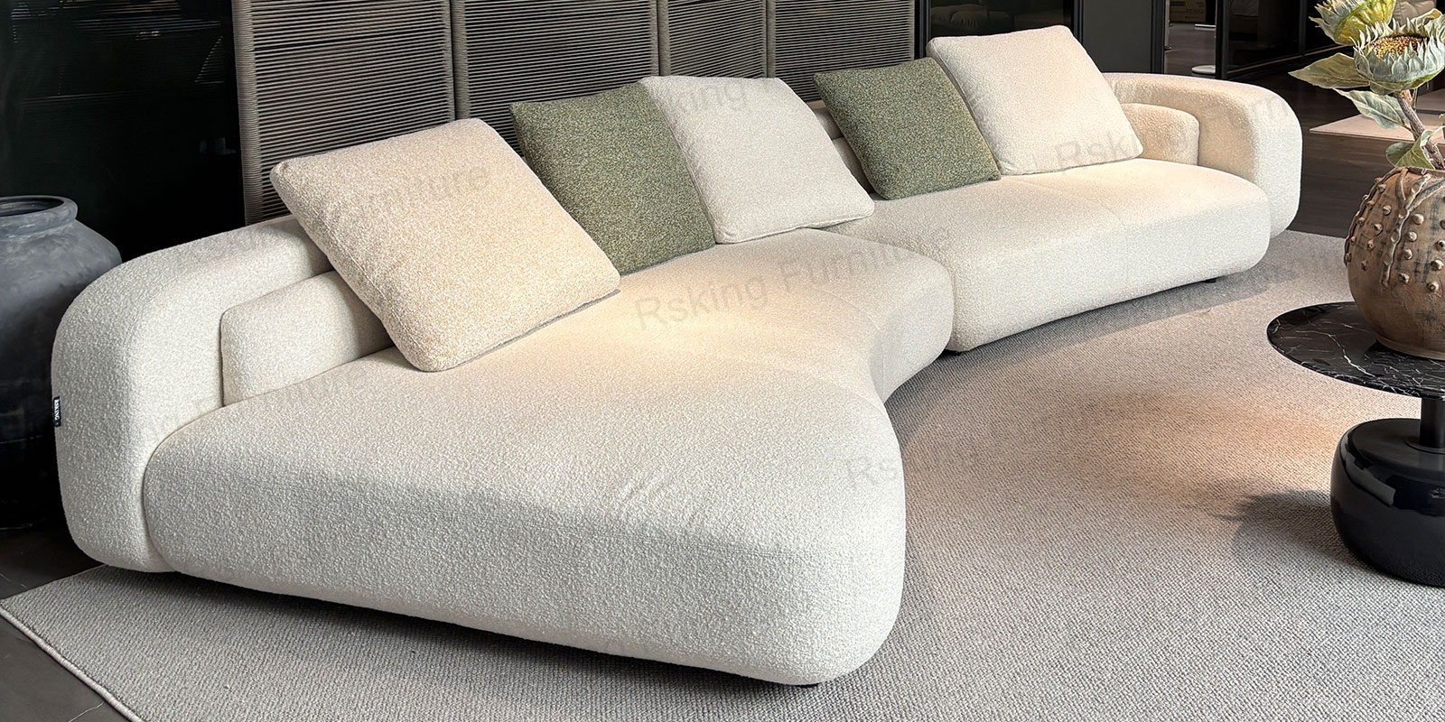 Close view of the Rsking RSK2560 rounded chaise and textured cream upholstery with contrasting green cushions
