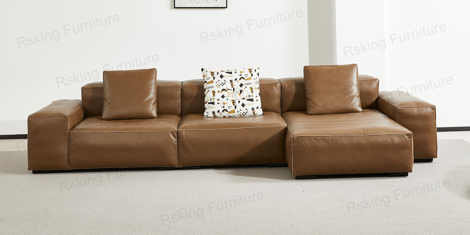 Caramel brown sofa in a shorter chaise configuration with square arms and patterned throw pillows