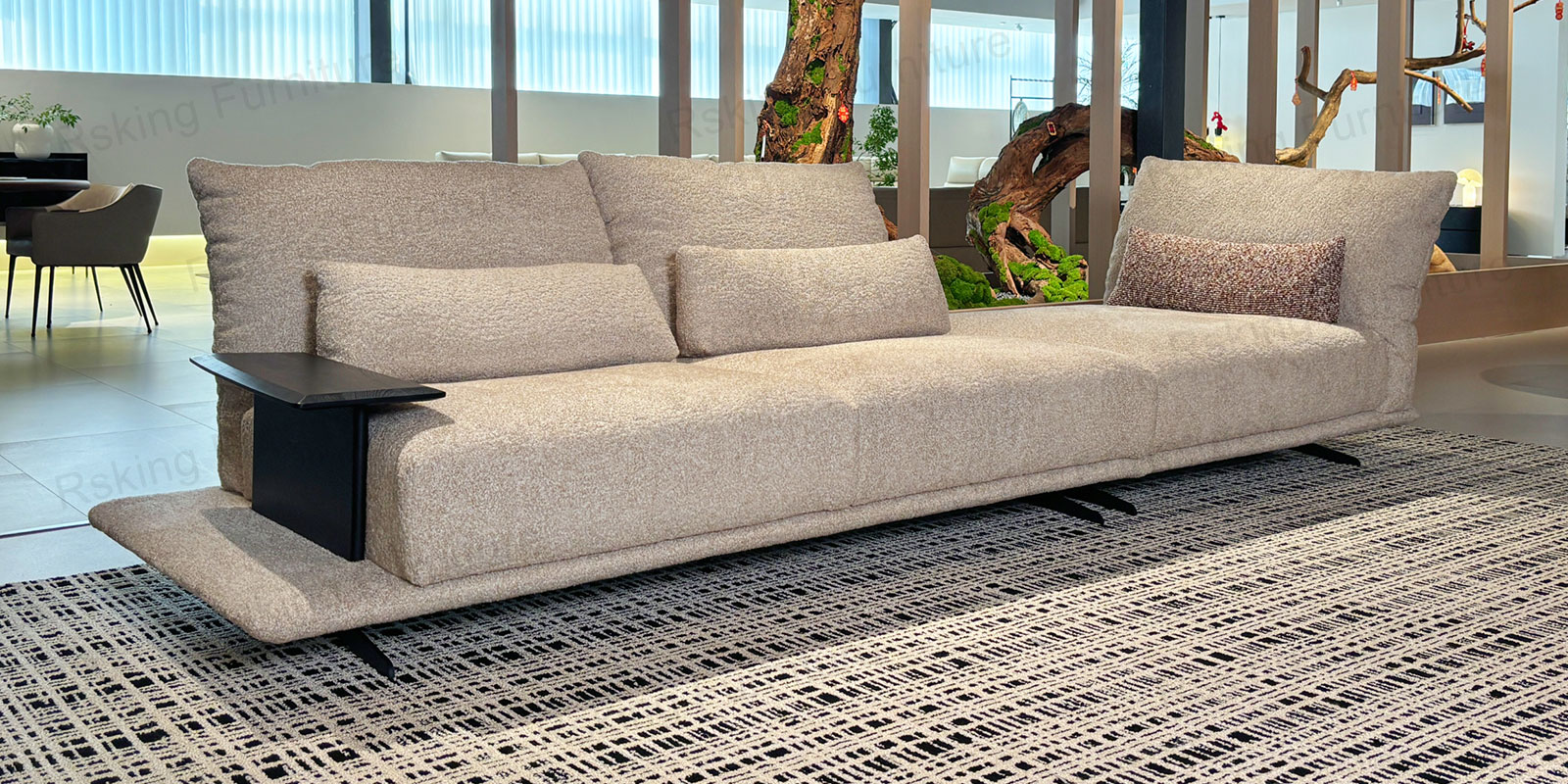 Angled showroom view of the off-white chenille sofa with textured cushions, wood armrest and dark legs
