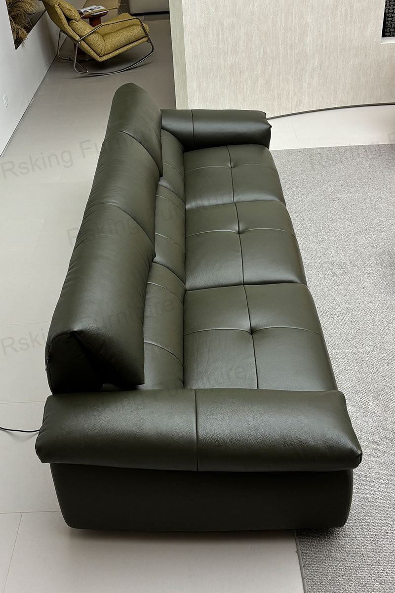 Elevated view of the olive green sofa showing geometric seat stitching and wide pillow-style arms